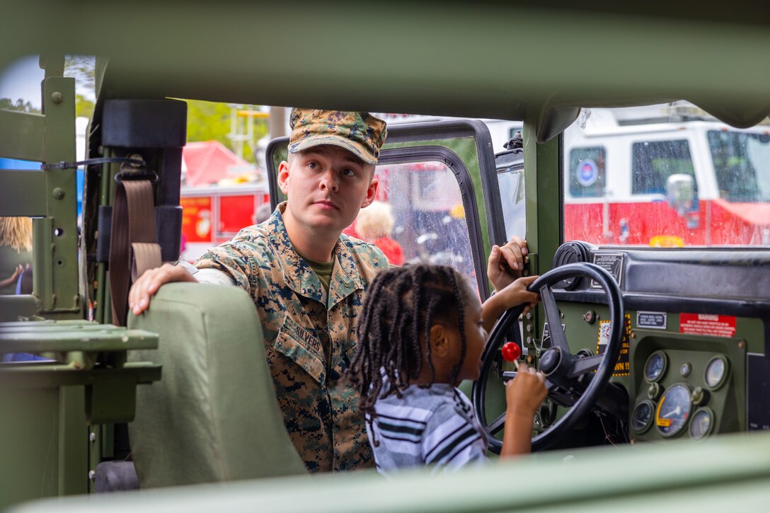 U.S. Marine Corps Lance Cpl. Matthew Silvers, a heavy equipment operator with Marine Wing Support Squadron 273, Marine Corps Air Station Beaufort, shows kids the inside of a military vehicle at the 24th Annual KidsFest at Cross Creek Shopping Center in Beaufort, South Carolina, April 2, 2022. The event is held every year to provide a fun and effective way of presenting resources available to families in the community during Month of the Military Child and Child Abuse Prevention Month. (U.S. Marine Corps photo by Sgt. Cheyeanne Campbell)