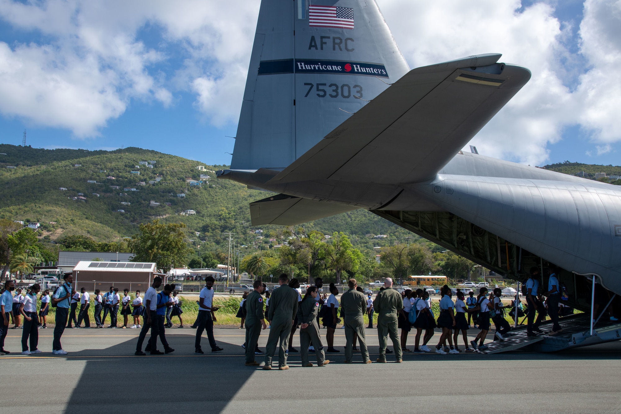 Students form a line going into the back of a WC-130J AIRCRAFT
