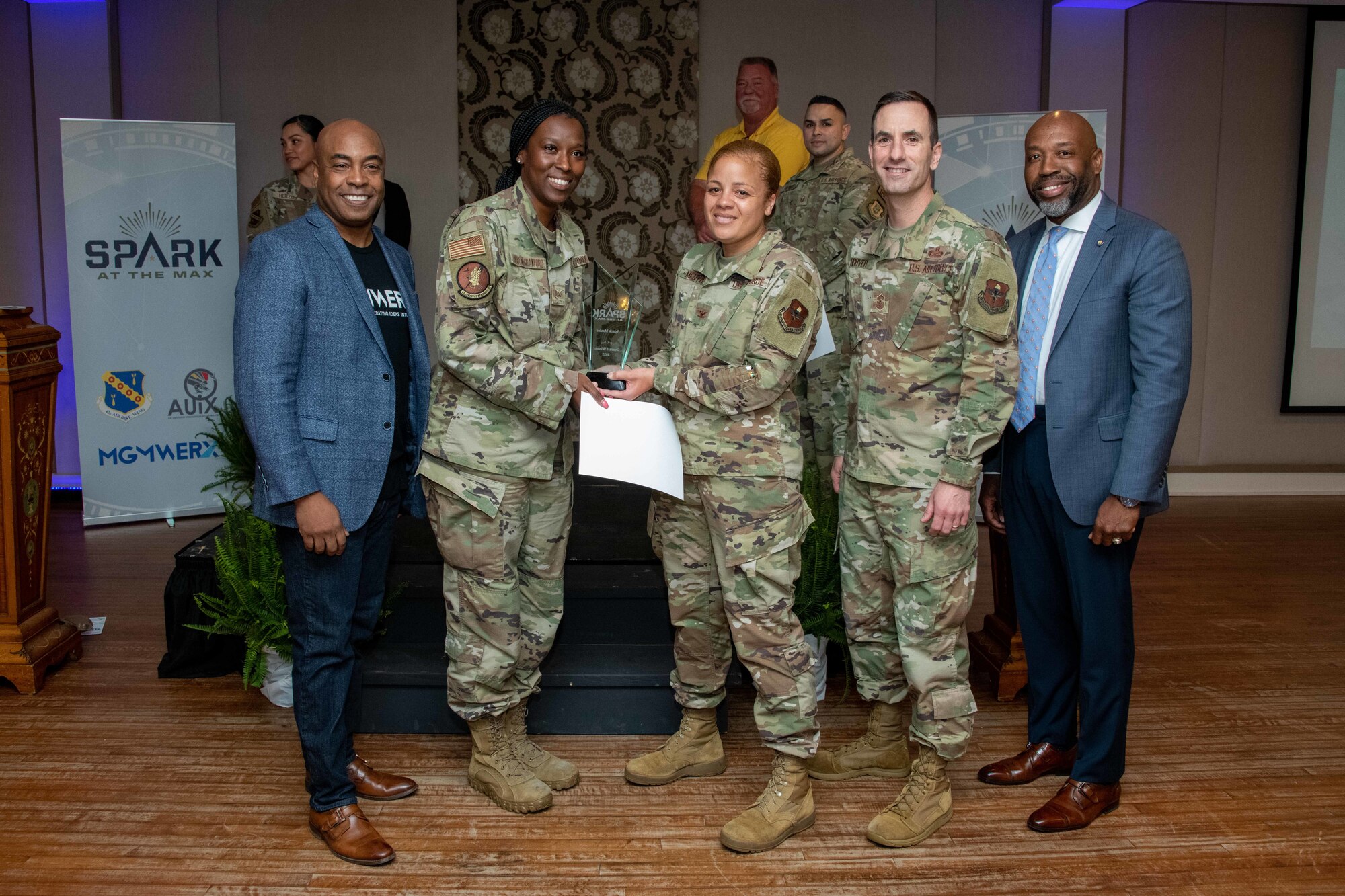 Maxwell AFB, Ala. – Staff Sgt. Audreianor Handsome-Crawford from the 42nd Logistics Readiness Squadron, poses for a photo with MGMWERX director Trent Edwards, Col. Eries Mentzer, Chief Master Sgt. Lee Hoover, and Terence Henderson during Spark at the Max, April 14, 2022. Handsome-Crawford won the first prize for her Warehouse Bay Door Automation innovation. (US Air Force photo by Melanie Rodgers Cox/Released)