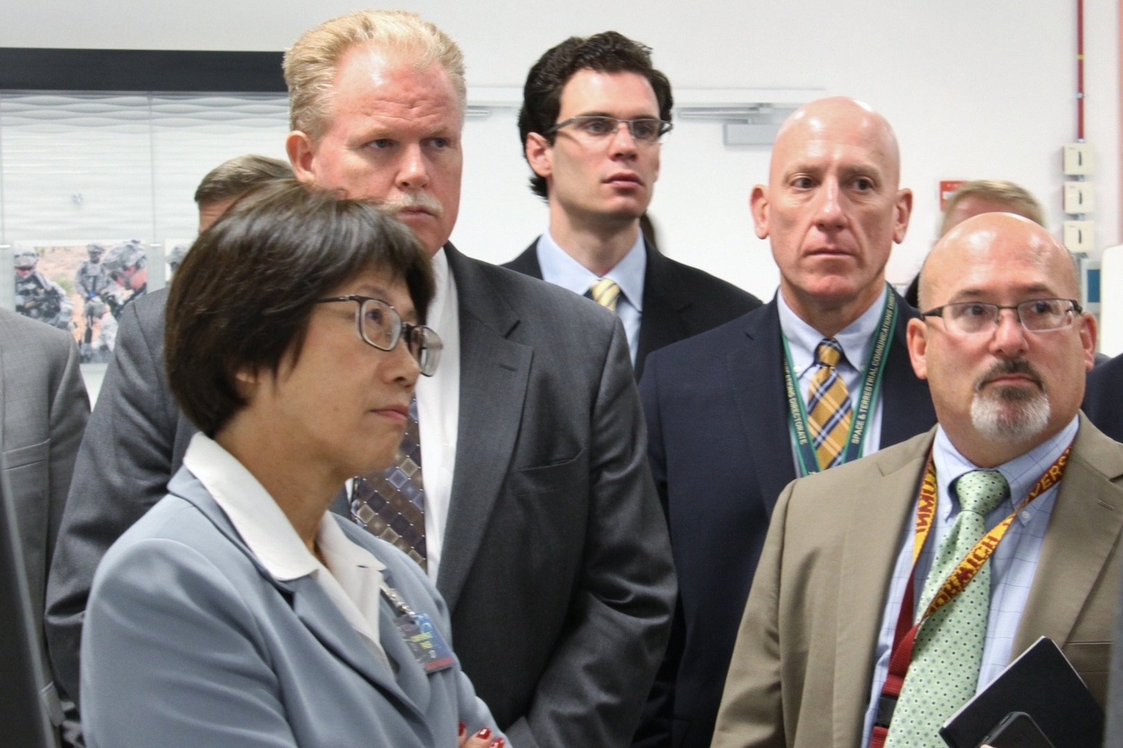 A woman is standing near four men.