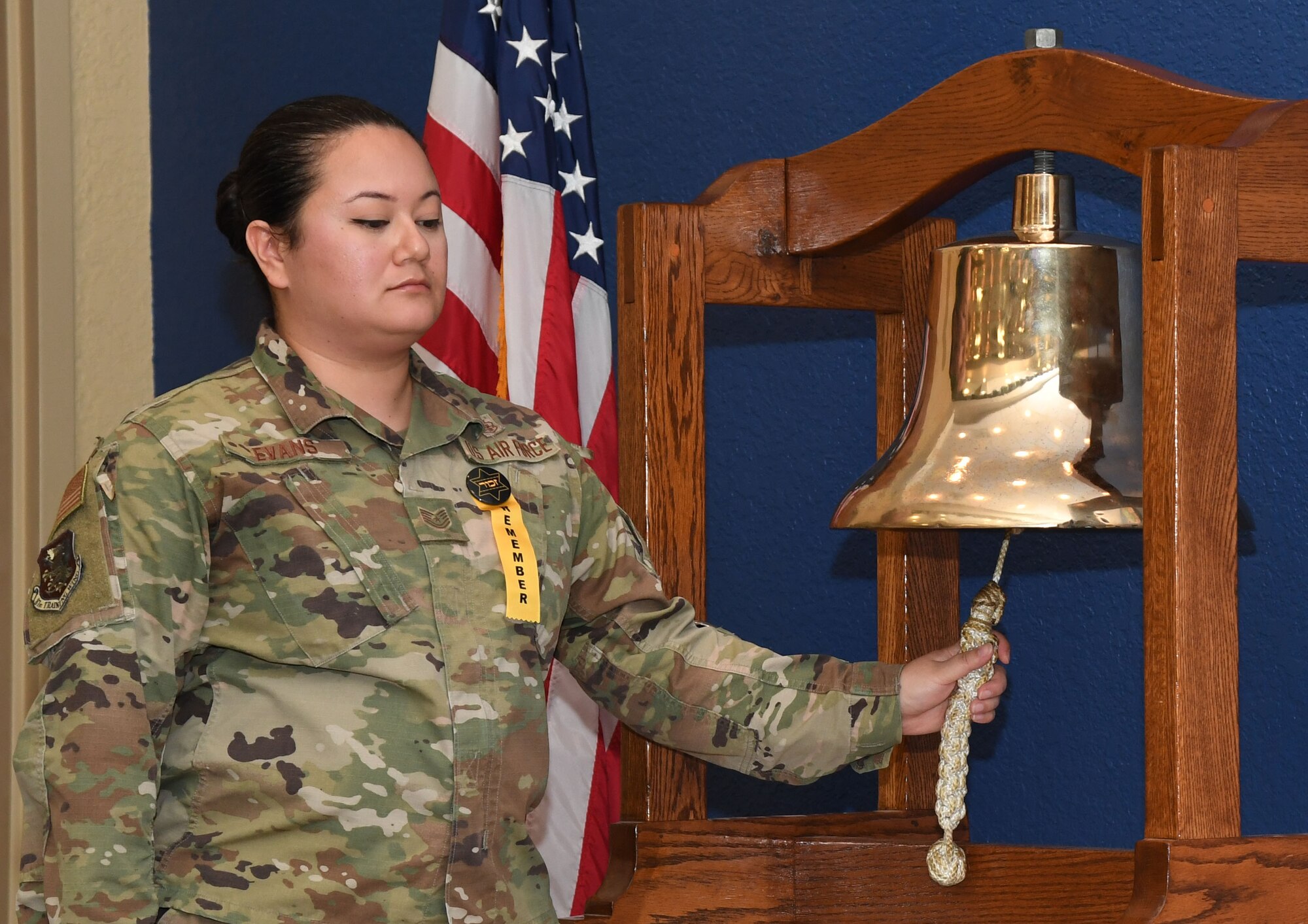 U.S. Air Force Tech. Sgt. Aprillesley Evans, 81st Diagnostic and Therapeutics Squadron laboratory technician, rings a bell in memory of 13 individuals who perished during the Holocaust with survivng relatives now living on the Gulf Coast during a Holocaust Remembrance Day event inside the Bay Breeze Event Center at Keesler Air Force Base, Mississippi, April 20, 2022. The event was held in memory of the six million Jewish victims of the Holocaust. (U.S. Air Force photo by Kemberly Groue).