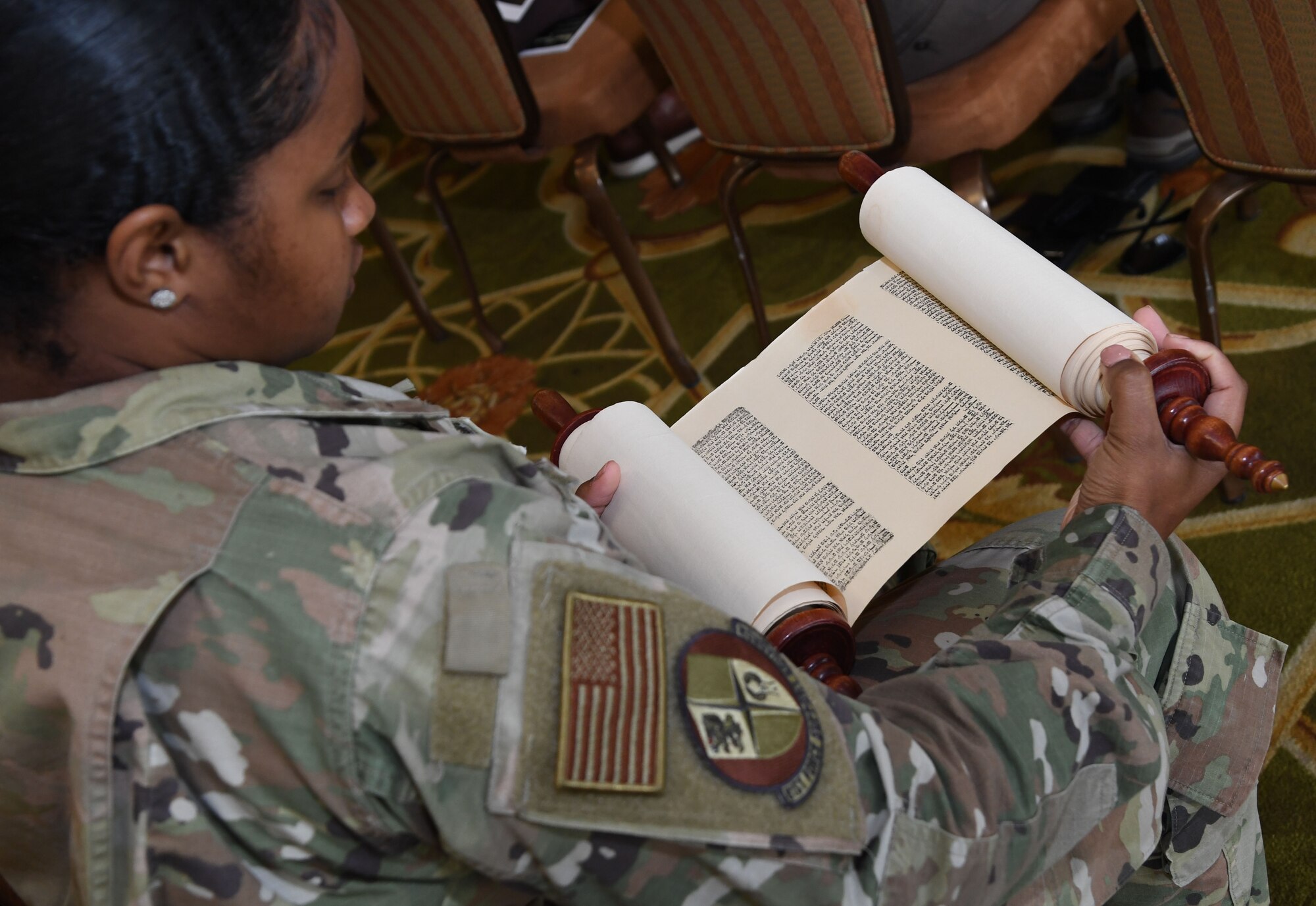 U.S. Air Force Staff Sgt. Neontra King, 81st Force Support Squadron student assignments NCO in charge, inspects a Torah during a Holocaust Remembrance Days of Remembrance event inside the Bay Breeze Event Center at Keesler Air Force Base, Mississippi, April 20, 2022. The event was held in memory of the six million Jewish victims of the Holocaust. (U.S. Air Force photo by Kemberly Groue)