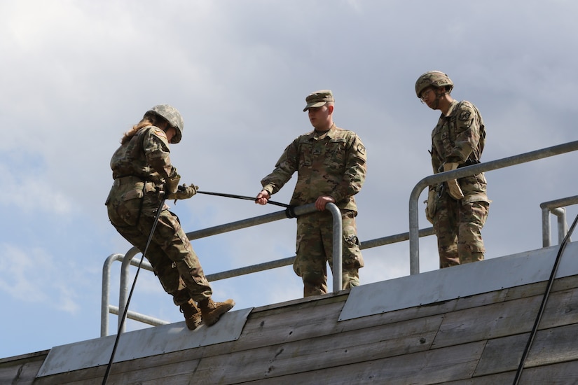 U.S. Army ROTC Cadet Elizabeth Ann Burke begins to rappel down a tower while participating in leadership training along with other students during a joint field training exercise at Fort Indiantown Gap, April 8, 2022. Burke is a freshman at Penn State University and native of Reston, Virginia. (U.S. Army National Guard photo by Spc. Annie M. Riley)