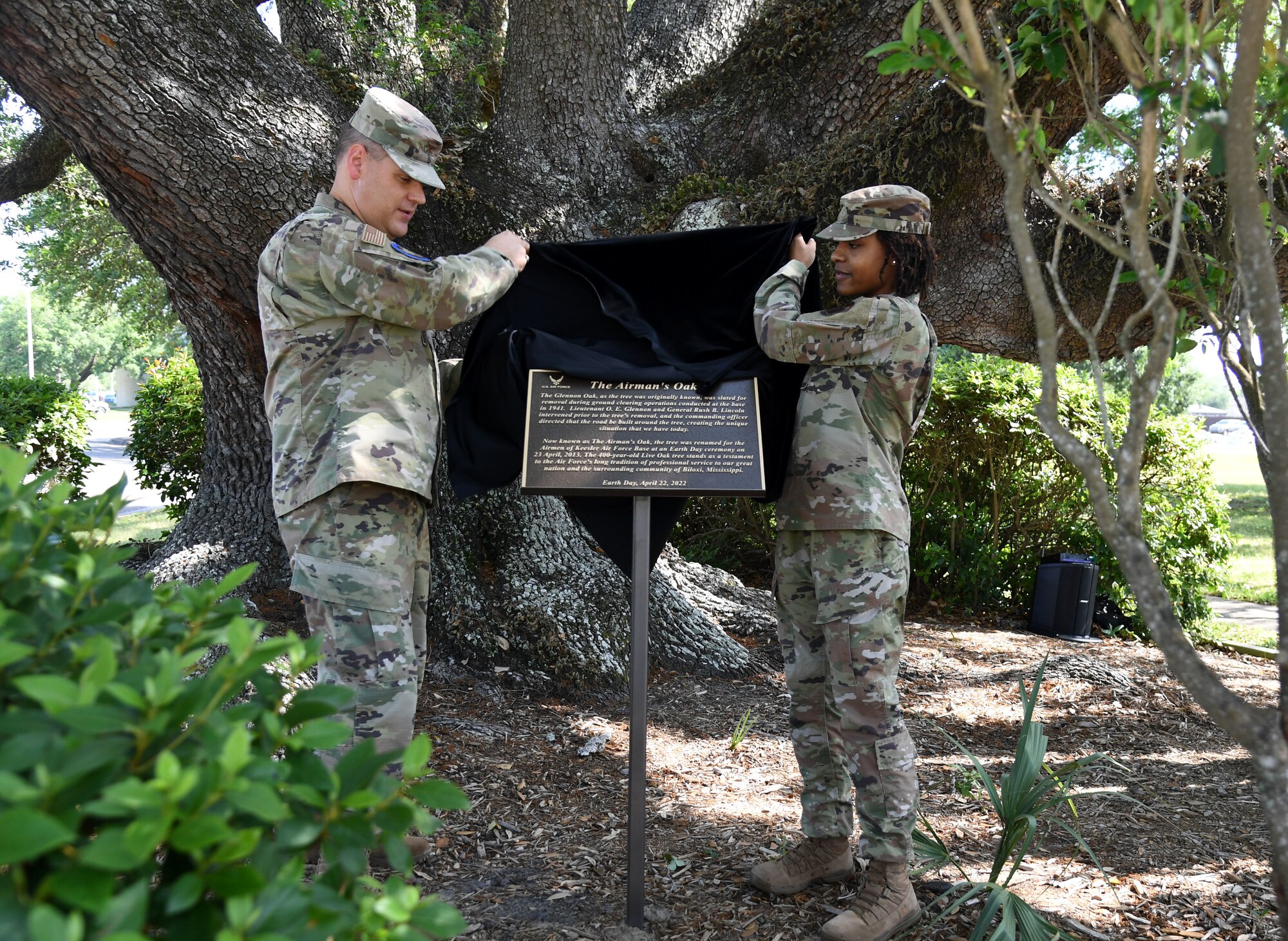 U.S. Air Force Col. James Kafer, 81st Training Wing vice commander, and Senior Airman Kaylahn Dargan-Williams, 81st Logistics Readiness Squadron logistics planner, unveil the Earth Day Airman's Oak Plaque during a ceremony at Keesler Air Force Base, Mississippi, April 22, 2022. The plaque was unveiled during the event to celebrate Earth Day, with this year's theme being “Invest in Our Planet." (U.S. Air Force photo by Kemberly Groue)