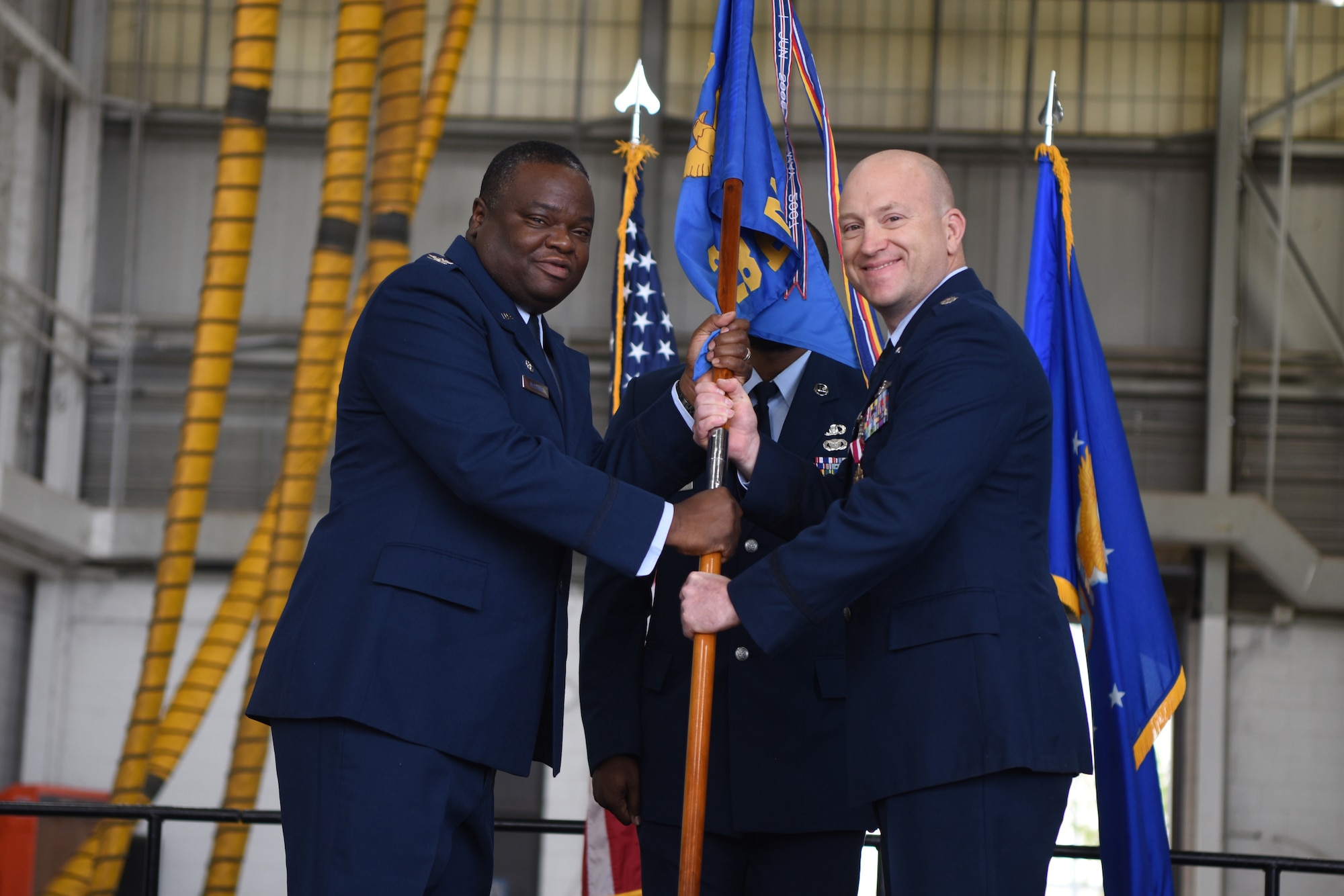 U.S. Air Force Col. John McClung, 7th Operations Group commander, takes the guidon from Lt. Col. Scott Thompson, outgoing 28th Bomb Squadron commander, during the 28th BS change of command ceremony inside the Three Bay Hangar at Dyess Air Force Base, Texas, April 22, 2022. The 28th BS is the largest bomb squadron in the Air Force and the largest flying squadron in Air Force Global Strike Command. (U.S. Air Force photo by Staff Sgt. Holly Cook)