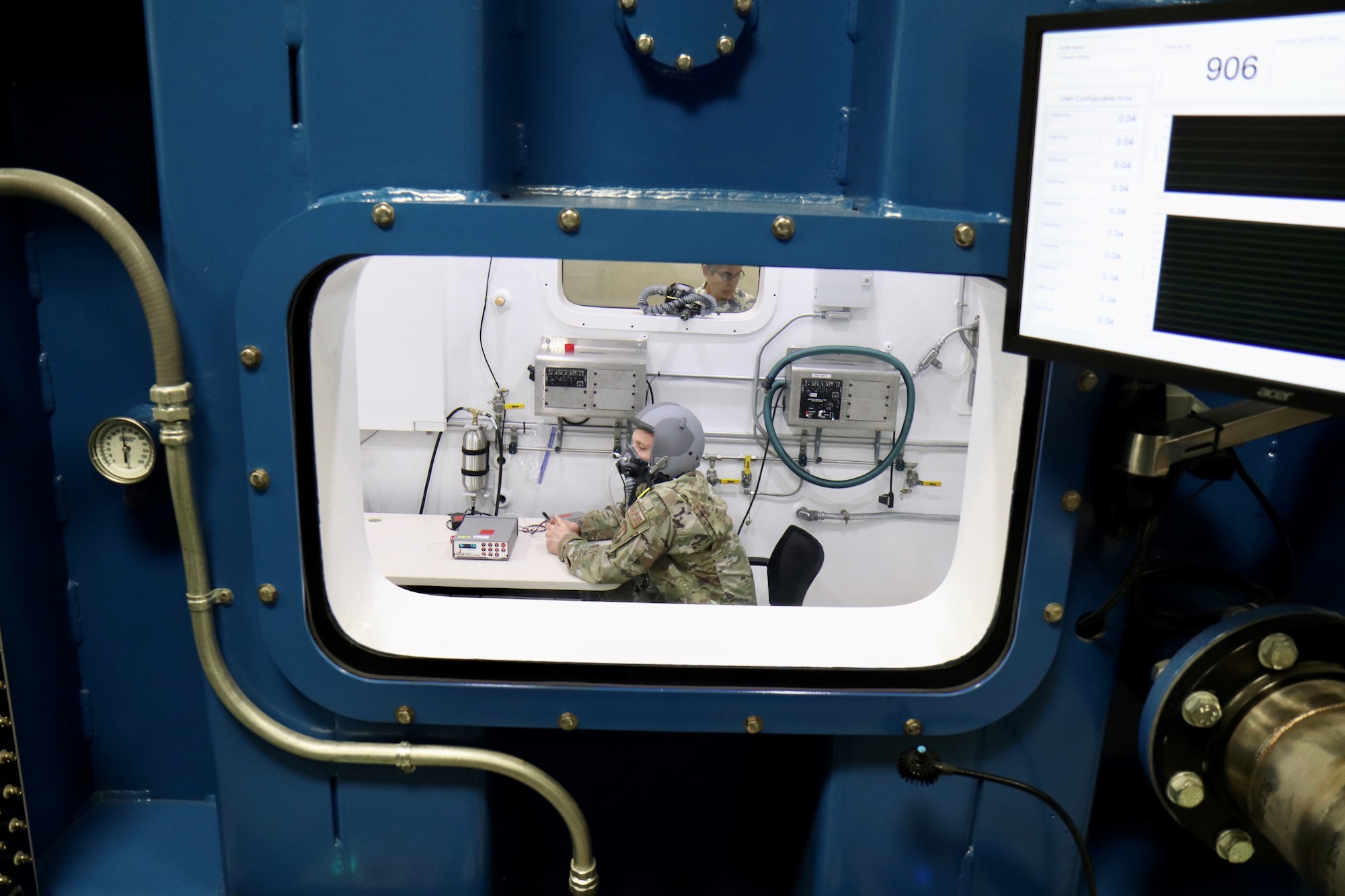 Tech. Sgt. Tyler Wineman sits inside a Research Altitude Chamber during an oxygen system test at Wright Patterson Air Force Base, Ohio, April 15, 2022. The chamber is one of three at the base that were certified in March for manned research up to 50,000 feet, a benchmark found nowhere else in the Department of Defense. Wineman is an aircrew flight equipment research technician assigned to the 711th Human Performance Wing, the Air Force Research Laboratory unit that operates the chambers. (U.S. Air Force photo/Jason Schaap)
