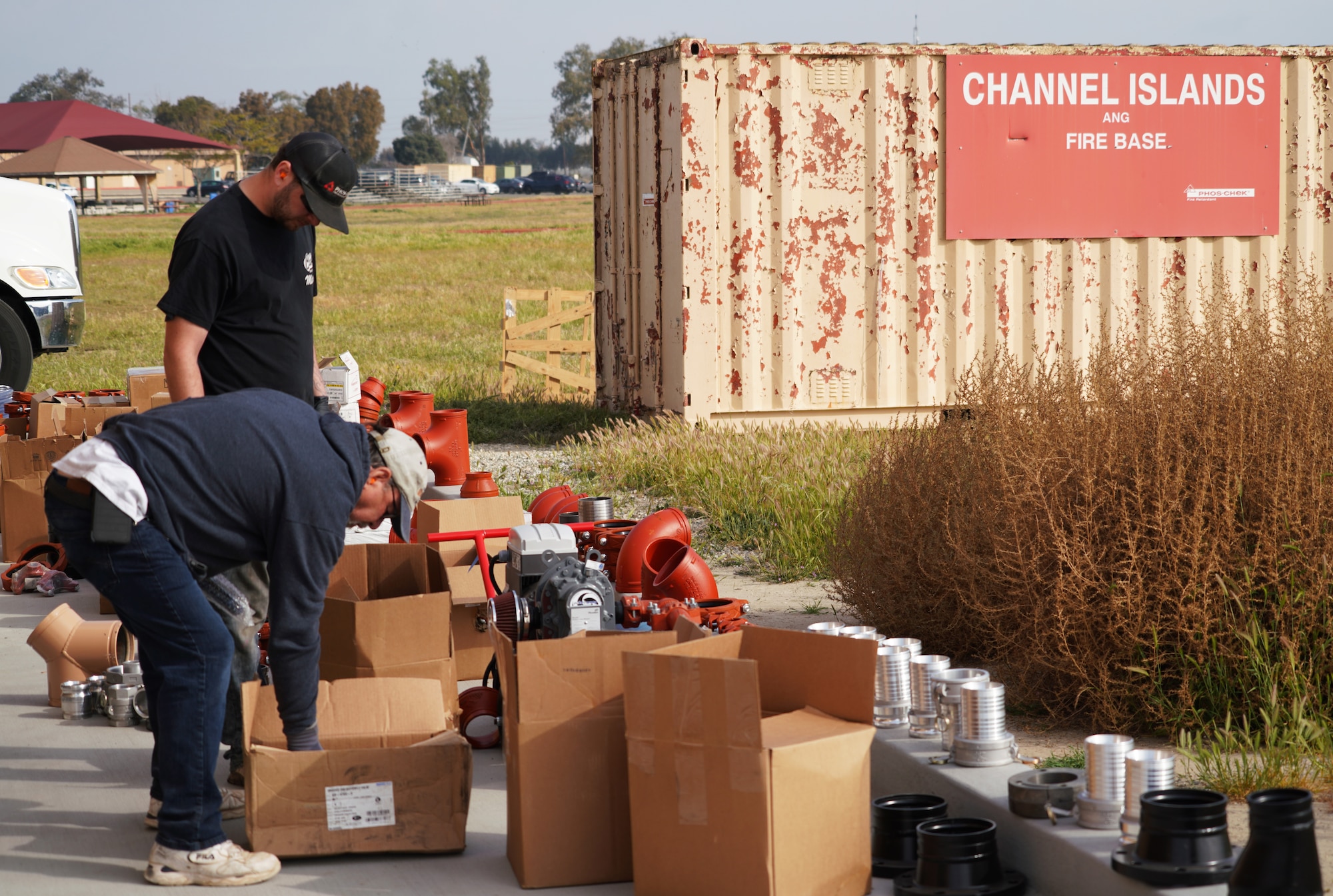 Willie Dayton, a senior field service technician and Ivan Ruhuhahsen, a service technician with Perimeter Solutions, organize parts for the 146th Airlift Wing's new Modular Airborne Firefighting System (MAFFS) Pits ground tanks at the Channel Islands Air National Guard Station, Port Hueneme, California. March 3, 2022. The new fire-retardant ground tanks have increased the storage capability five-fold from a 10,000-gallon capacity to 50,000 gallons to accommodate more MAFFS aircraft and the U.S. Forest Service's Very Large Air Tankers (VLAT's) with water and fire retardant solution. (U.S. Air National Guard photo by Staff Sgt. Michelle Ulber)