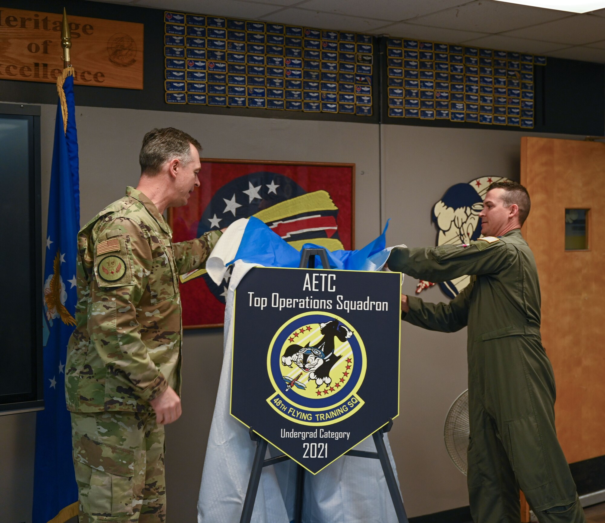 Maj. Gen. Craig D. Wills, 19th Air Force commander, and Lt. Col. Nelson Prouty, 48th Flying Training Squadron commander, unveil a poster to signify the 48th FTS as the Air Education and Training Command’s top operations squadron for 2021 on April 20, 2022, at Columbus Air Force Base, Miss. The mission of the 48th FTS is to develop professional military officers while empowering instructors to train pilots for the world’s greatest Air Force. (U.S. Air Force photo by Senior Airman Davis Donaldson)