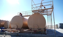 Levi Mello, a service technician with Perimeter Solutions, tightens a valve on the 146th Airlift Wing's new Modular Airborne Firefighting System (MAFFS) pits ground tanks at Channel Island Air National Guard Station, Port Hueneme, California. March 9, 2022. The new fire-retardant ground tanks have increased the storage capability five-fold from a 10,000-gallon capacity to 50,000 gallons to accommodate more MAFFS aircraft and the U.S. Forest Service's Very Large Air Tankers (VLAT's) with water and fire retardant solution. (U.S. Air National Guard photo by Staff Sgt. Michelle Ulber)