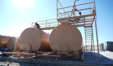 Levi Mello, a service technician with Perimeter Solutions, tightens a valve on the 146th Airlift Wing's new Modular Airborne Firefighting System (MAFFS) pits ground tanks at Channel Island Air National Guard Station, Port Hueneme, California. March 9, 2022. The new fire-retardant ground tanks have increased the storage capability five-fold from a 10,000-gallon capacity to 50,000 gallons to accommodate more MAFFS aircraft and the U.S. Forest Service's Very Large Air Tankers (VLAT's) with water and fire retardant solution. (U.S. Air National Guard photo by Staff Sgt. Michelle Ulber)