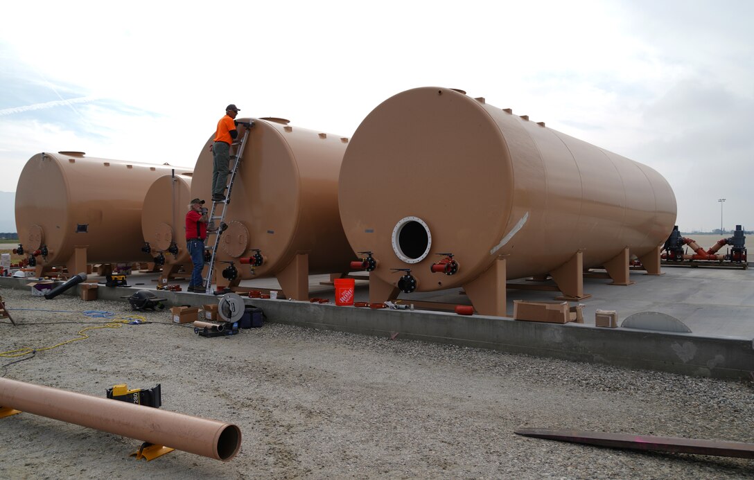 Darrin Hutchison and Tom Miszklevitz, managers with Perimeter Solutions, adjust a nozzle on the 146th Airlift Wing's new Modular Airborne Firefighting System (MAFFS) Pits Ground Tanks, Channel Islands Air National Guard Station, Port Hueneme, California. March 3, 2022. The new fire-retardant ground tanks have increased the storage capability five-fold from a 10,000-gallon capacity to 50,000 gallons to accommodate more MAFFS aircraft and the U.S. Forest Service's Very Large Air Tankers (VLAT's) with water and fire retardant solution. (U.S. Air National Guard photo by Staff Sgt. Michelle Ulber)