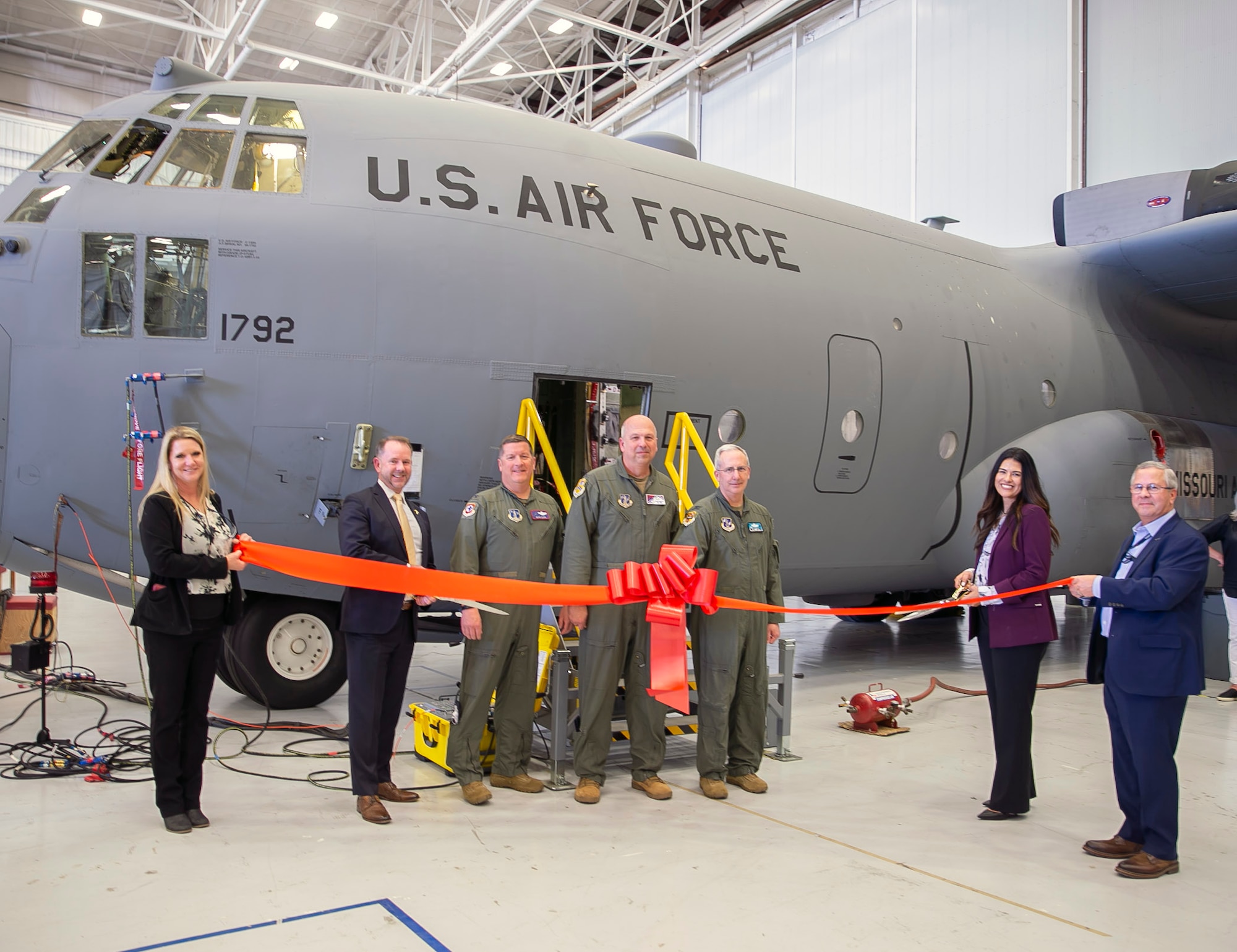 Pictured left to right:  Michelle Miller (L3H), Dr. Joseph Peloquin (C-130 Hercules Division), Col. John Cluck (139th Airlift Wing), Col. Dean Martin (189th Airlift Wing), Col. Barry Deibert (153rd Airlift Wing), Sara Tatsch (L3H) and David Norsworthy (L3H), during a ribbon cutting ceremony to mark the completion of the first Trial Kit Installation (TKI) onto a C-130H from the 139th Airlift Wing. (Courtesy photo)