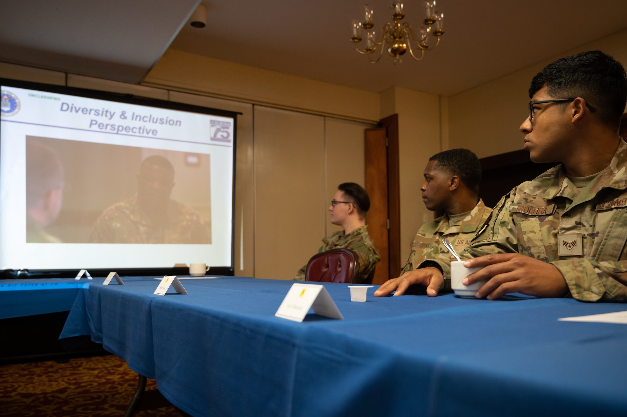 Three Airmen watch a video