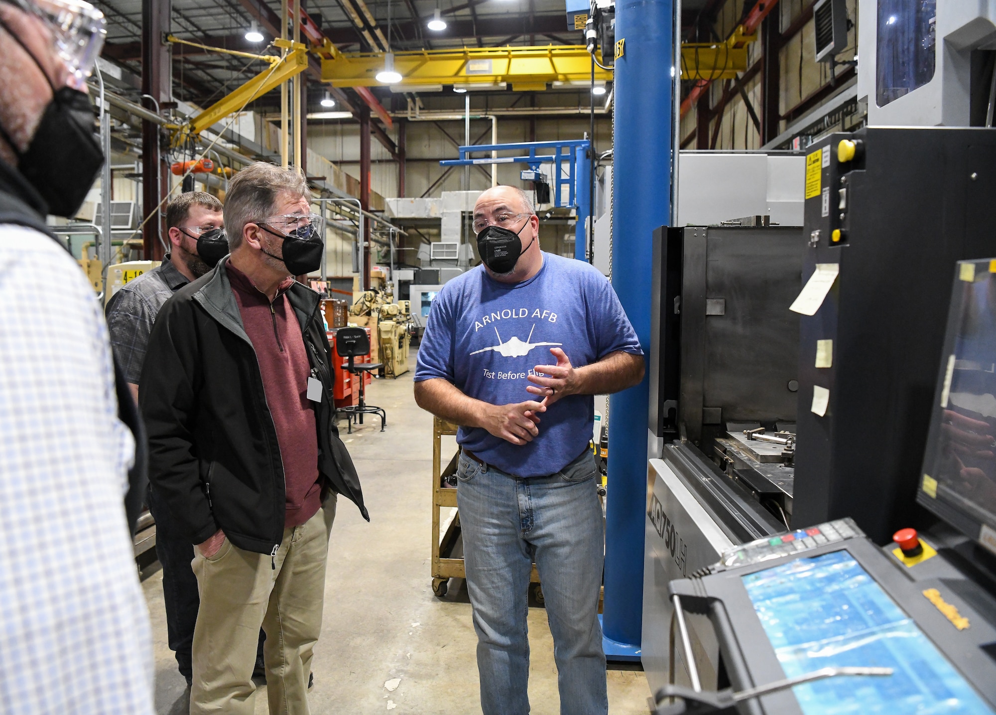 Bob Williams, right, Precision Machine Shop supervisor with the Test Operations and Sustainment contractor for Arnold Engineering Development Complex, answers questions from local teachers and school administrators during a tour of facilities at Arnold Air Force Base, Tenn., Feb. 23, 2022. Also pictured are Derek Rowe, center, aerospace and flight teacher for Tullahoma High School, and Derek Swiger, left, machine shop teacher for Tullahoma High School. The educators were being shown the trade job opportunities available at the base to be able to share the information with their students. (U.S. Air Force photo by Jill Pickett) (This image has been altered by obscuring a badge for security purposes.)