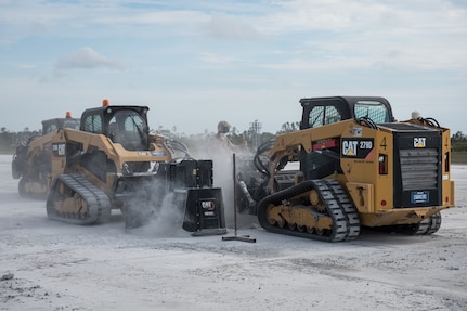 U.S. Air Force Airmen use compact track loaders attached with skid steer saws to remove damaged concrete on the runway during RADR (Rapid Airfield Damage Repair) operations at the Silver Flag exercise site on Tyndall Air Force Base, Florida, March 31, 2022. The primary focus of Silver Flag is to teach Airmen from the civil engineer, force support, and vehicle maintenance squadrons essential skills to complete operations outside of their primary duties. (U.S. Air National Guard photo by Senior Airman Jana Somero)