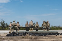 U.S. Air Force Airmen carry the FRP (Fiber-Reinforced Polymer) to cover a crater on the runway at the Silver Flag exercise site on Tyndall Air Force Base, Florida, March 31, 2022. The primary focus of Silver Flag is to teach Airmen from the civil engineer, force support, and vehicle maintenance squadrons essential skills to complete operations outside of their primary duties. (U.S. Air National Guard photo by Senior Airman Jana Somero)