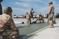 U.S. Air Force Airmen assemble the FRP (Fiber-Reinforced Polymer) to cover a crater on the runway at the Silver Flag exercise site on Tyndall Air Force Base, Florida, March 31, 2022. The primary focus of Silver Flag is to teach Airmen from the civil engineer, force support, and vehicle maintenance squadrons essential skills to complete operations outside of their primary duties. (U.S. Air National Guard photo by Senior Airman Jana Somero)