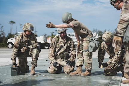 U.S. Air Force Airmen assemble the FRP (Fiber-Reinforced Polymer) to cover a crater on the runway at the Silver Flag exercise site on Tyndall Air Force Base, Fla., March 31, 2022. The primary focus of Silver Flag is to teach Airmen from the civil engineer, force support, and vehicle maintenance squadrons essential skills to complete operations outside of their primary duties. (U.S. Air National Guard photo by Senior Airman Jana Somero)