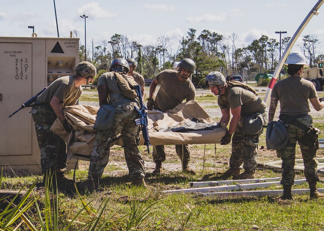 U.S. Air Force Airmen prepare to erect an Alaskan Small Shelter System at the Silver Flag exercise site at Tyndall Air Force Base, Florida, March 31, 2022. The primary focus of Silver Flag is to teach Airmen from the civil engineer, force support, and vehicle maintenance squadrons essential skills to complete operations outside of their primary duties. (U.S. Air National Guard photo by Senior Airman Jana Somero)