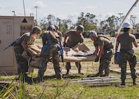 U.S. Air Force Airmen prepare to erect an Alaskan Small Shelter System at the Silver Flag exercise site at Tyndall Air Force Base, Florida, March 31, 2022. The primary focus of Silver Flag is to teach Airmen from the civil engineer, force support, and vehicle maintenance squadrons essential skills to complete operations outside of their primary duties. (U.S. Air National Guard photo by Senior Airman Jana Somero)