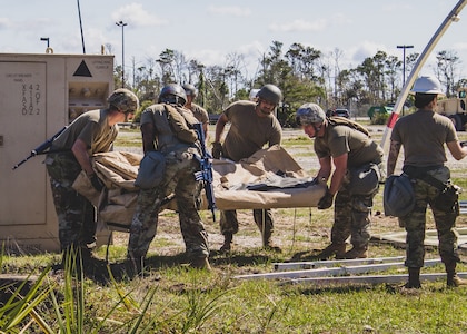 U.S. Air Force Airmen prepare to erect an Alaskan Small Shelter System at the Silver Flag exercise site at Tyndall Air Force Base, Florida, March 31, 2022. The primary focus of Silver Flag is to teach Airmen from the civil engineer, force support, and vehicle maintenance squadrons essential skills to complete operations outside of their primary duties. (U.S. Air National Guard photo by Senior Airman Jana Somero)