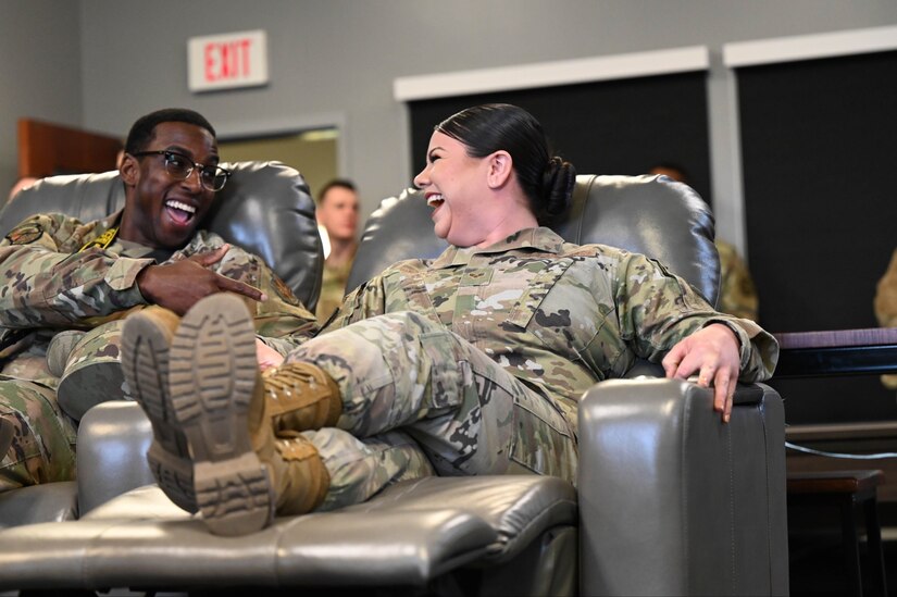 Senior Airman Doman Mackin and Claudia Mendez, enjoy the newly installed theater style recliners in the United Service Organization resiliency room April, 12, 2022 at Joint Base Anacostia-Bolling, DC. Renovations of the room were budgeted at about $62,000 and completed over the course of several months. (U.S. Air Force photo by Senior Airman Nilsa Garcia)