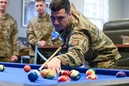 Senior Airman Maison Hayes, United States Air Force Honor Guard ceremonial guardsman, plays a game of pool during the opening of the United Service Organization resiliency room April, 12, 2022 at Joint Base Anacostia-Bolling, DC. The new accommodations in the resiliency room aspire to provide a place for Airmen within the Honor Guard to foster resilience, care and camaraderie. (U.S. Air Force photo by Senior Airman Nilsa Garcia)