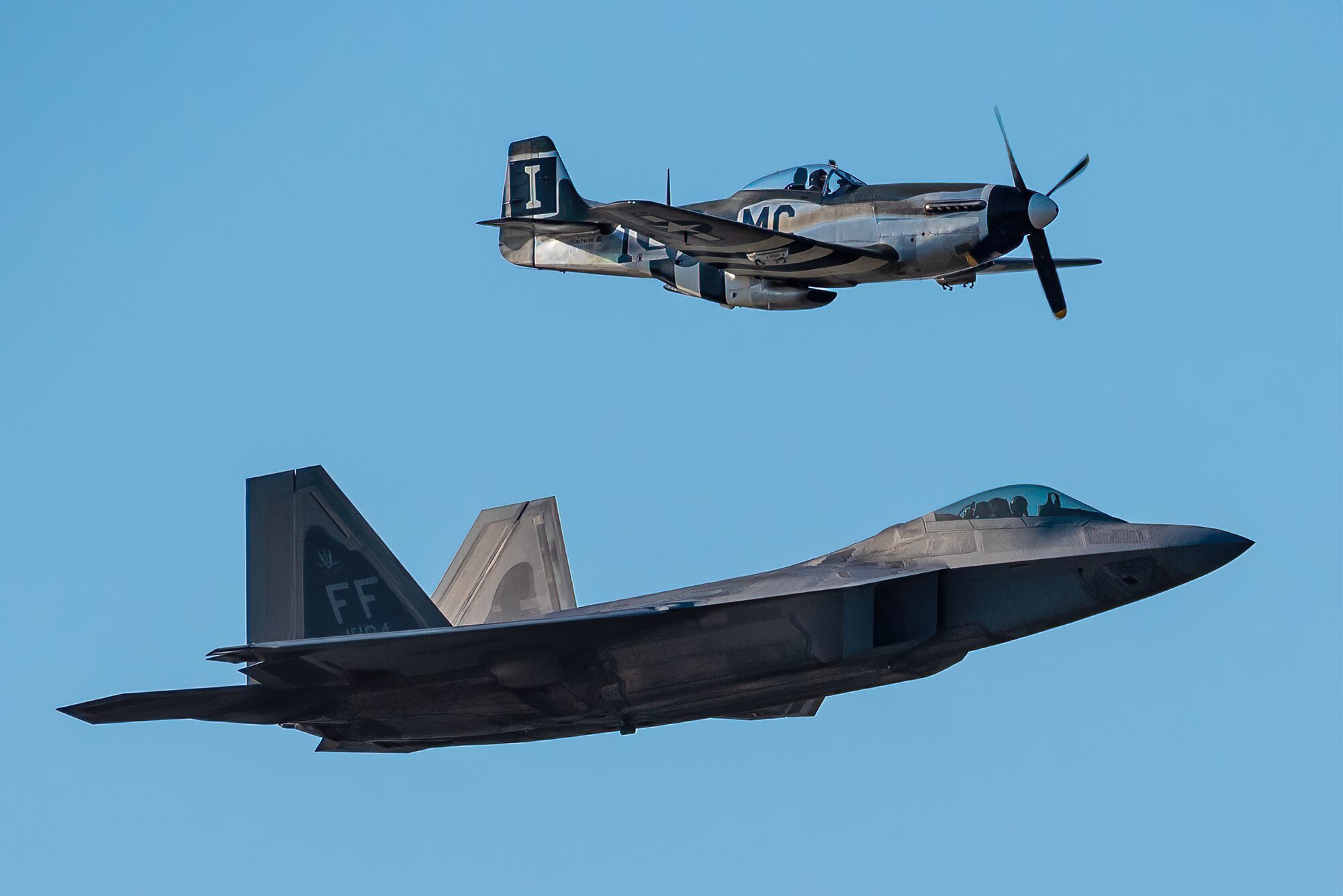 A heritage flight consisting of a World War II-era P-51D Mustang and a modern U.S. Air Force F-22 Raptor performs an aerial demonstration over the Ohio River in downtown Louisville, Ky., April 23, 2022 as part of the Thunder Over Louisville air show. This year’s event celebrated the 75th anniversary of the United States Air Force. (U.S. Air National Guard photo by Dale Greer)