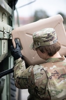 a female sergeant refuels a vehicle