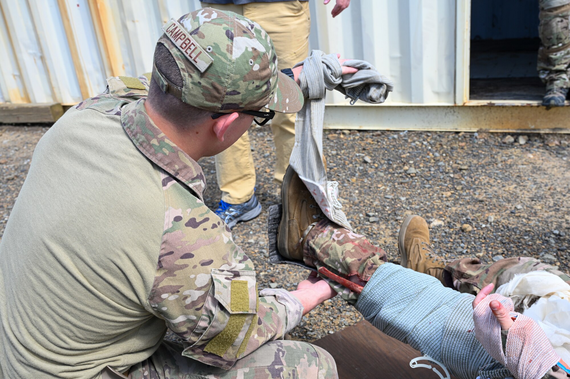 Senior Airman Christian Campbell, 19th Civil Engineer Squadron explosive ordnance disposal technician, applies a bandage on a simulated injured patient