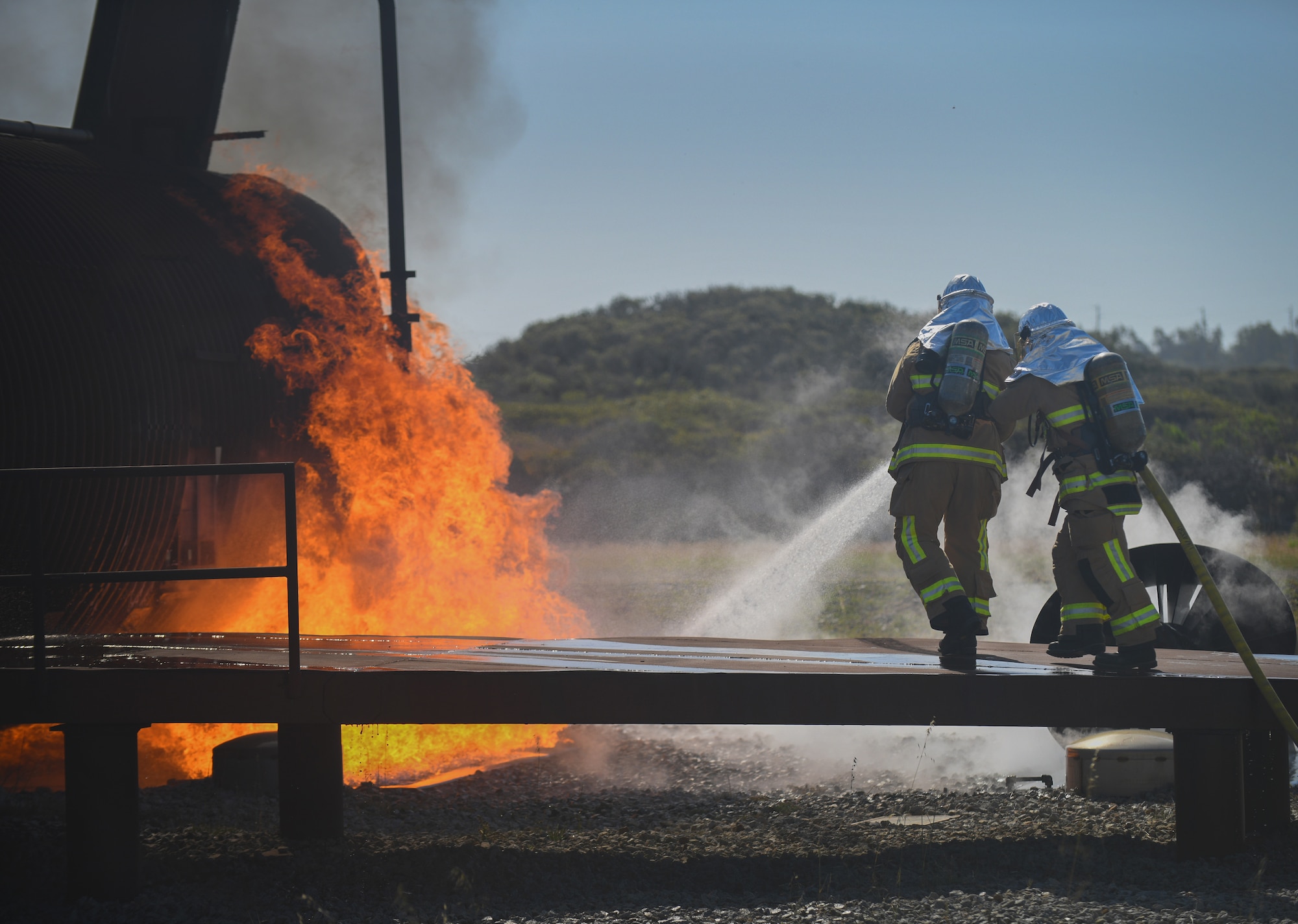 A team of firefighters put out a fire around a training aircraft prior to entering during the joint firefighter integrated readiness ensemble training exercise on Vandenberg Space Force Base, Calif., April 7, 2022. The Vandenberg Fire Department trains on JFIRE annually to retain their certification. (U.S. Space Force photo by Airman 1st Class Ryan Quijas)