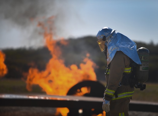 Airman Anthony Joey Crow, 30th CES firefighter, looks on as other teams enter an aircraft to put out fires during the joint fire integrated readiness ensemble training exercise on Vandenberg Space Force Base, Calif., April 7, 2022. During the live fire portion of the training, there is a team on a vehicle spraying water around the training aircraft, another team on a hose putting out fires around the aircraft as well as inside the aircraft. (U.S. Space Force photo by Airman 1st Class Ryan Quijas)