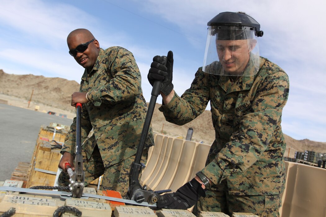 Photo of Marines crumping a band around a shipment of ammunition