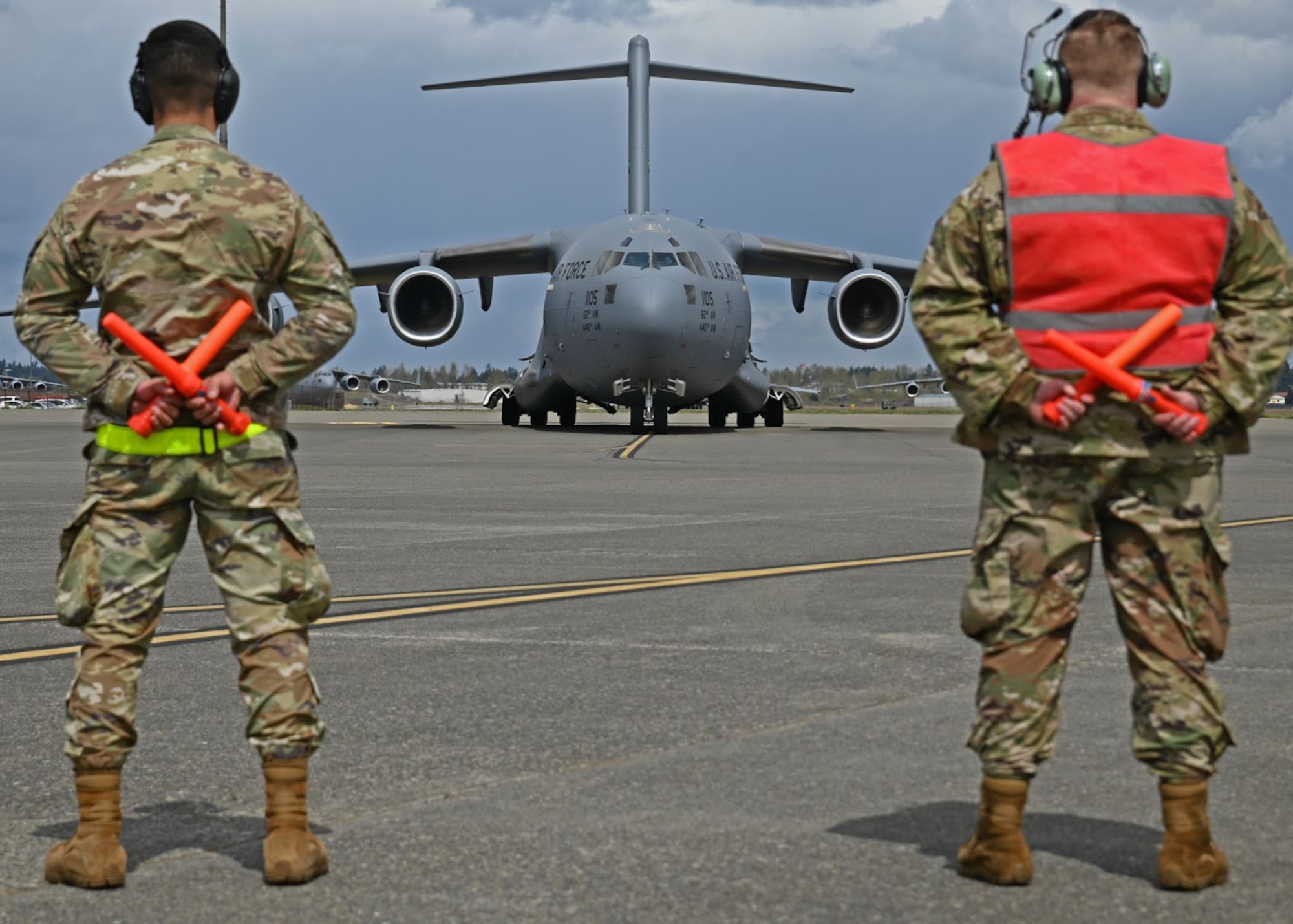 U.S. Air Force Airman 1st Class Michael Eresh-Archuleta, left, material management journeyman with the 627th Logistics Readiness Squadron, and Staff Sgt. Oden Bagley, aircraft hydraulics specialist with the 62nd Maintenance Squadron, marshall out a C-17 Globemaster III during Agile Combat Employment Training at Joint Base Lewis-McChord, Washington, April 21, 2022. The week-long ACE training focuses on taking the six primary maintenance Air Force Specialty Codes and combining them into two categories, mechanics and technicians. (U.S. Air Force photo by Airman 1st Class Callie Norton)