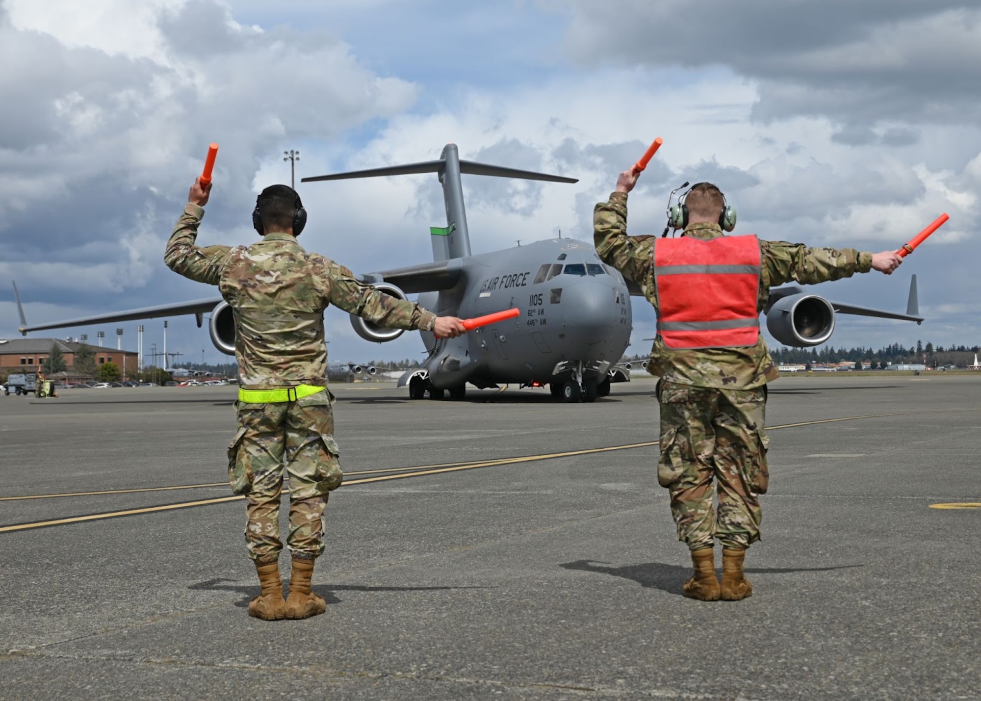 U.S. Air Force Airman 1st Class Michael Eresh-Archuleta, left, material management journeyman with the 627th Logistics Readiness Squadron, and Staff Sgt. Oden Bagley, aircraft hydraulics specialist with the 62nd Maintenance Squadron, marshall out a C-17 Globemaster III during Agile Combat Employment Training at Joint Base Lewis-McChord, Washington, April 21, 2022. The week-long ACE training reinforces the team dynamic required for maintenance Airmen to operate effectively in limited support locations while continuing to maintain mission effectiveness. (U.S. Air Force photo by Airman 1st Class Callie Norton)