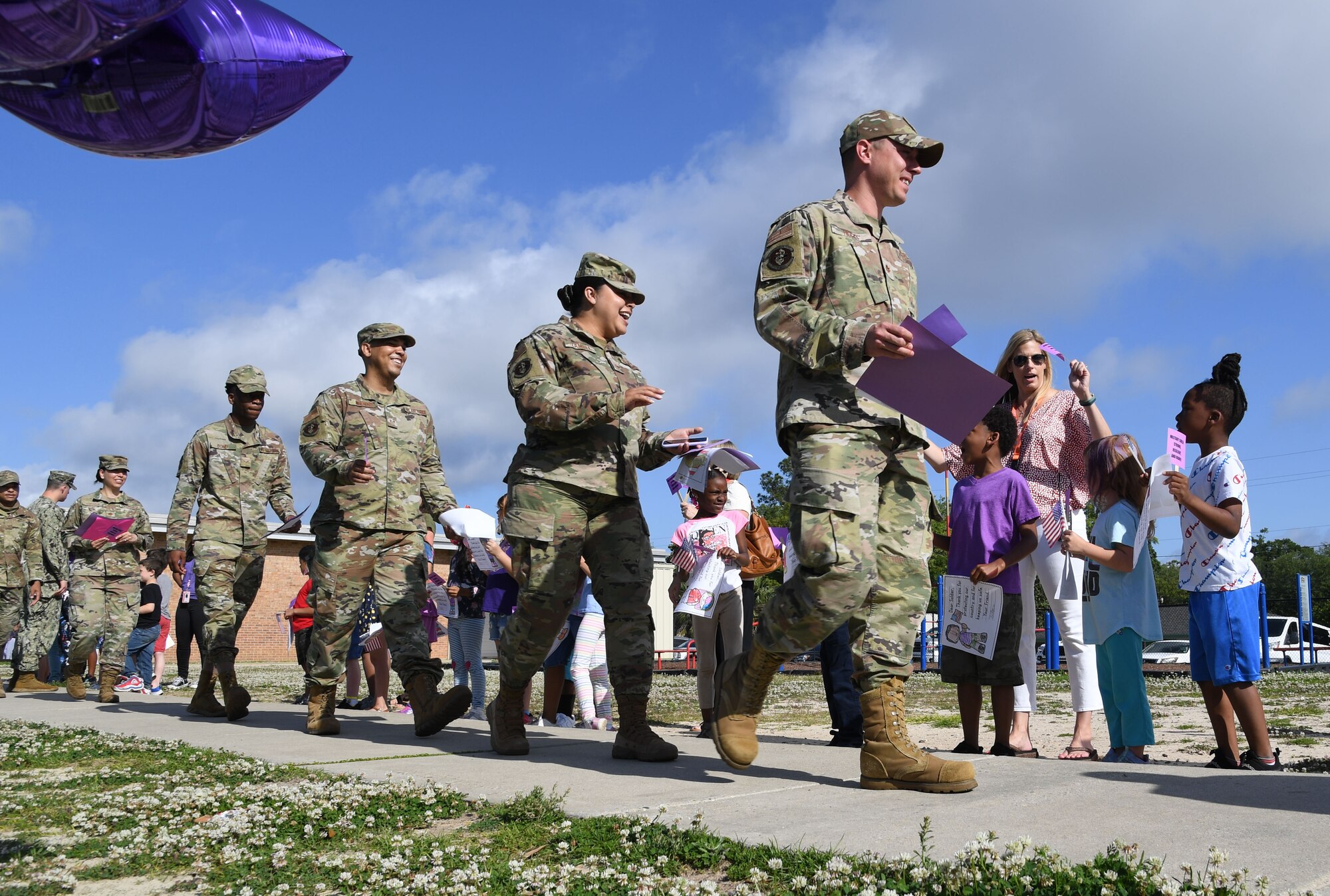 Keesler personnel participate in the Back Bay Elementary School Military Honor Walk in Biloxi, Mississippi, April 25, 2022. The walk, held in recognition of the Month of the Military Child, allows students the opportunity to honor all military personnel affiliated with the school and the surrounding community. (U.S. Air Force photo by Kemberly Groue)