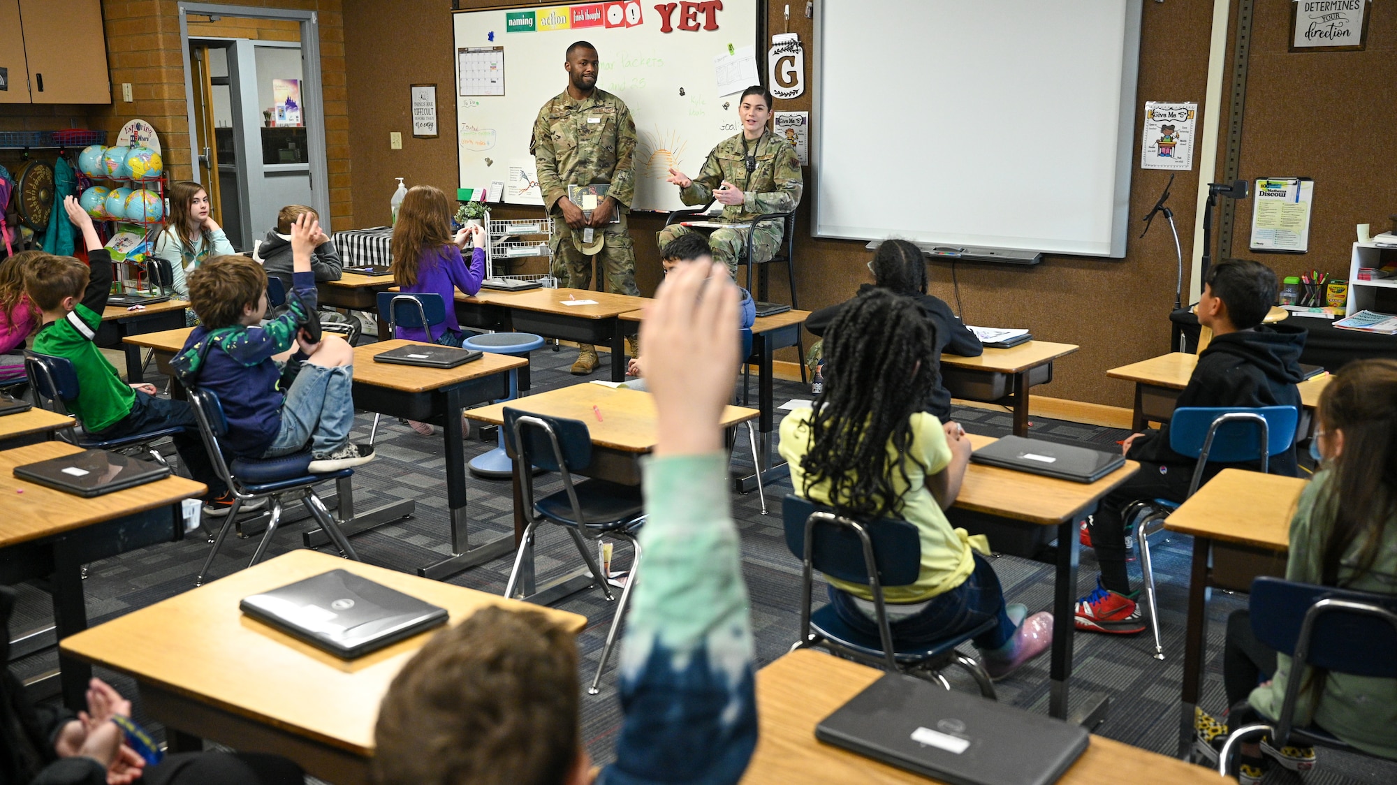 Senior Airman Rachel Hodge, right, and Senior Airman Tyrell Keys, 388th Operations Support Squadron, speak with students at Hill Field Elementary School during a Heroes Reading event, April 22, 2022. The Heroes Reading program is an annual event conducted by the Hill AFB School Liaison office in partnership with local elementary schools. The event is held each spring in conjuction with April's Month of the Military Child. This year marks a relaunch of the program after a hiatus due to the COVID-19 pandemic. During the month, Airmen volunteers will visit three schools and read to more than 1,400 students. (U.S. Air Force photo by R. Nial Bradshaw)
