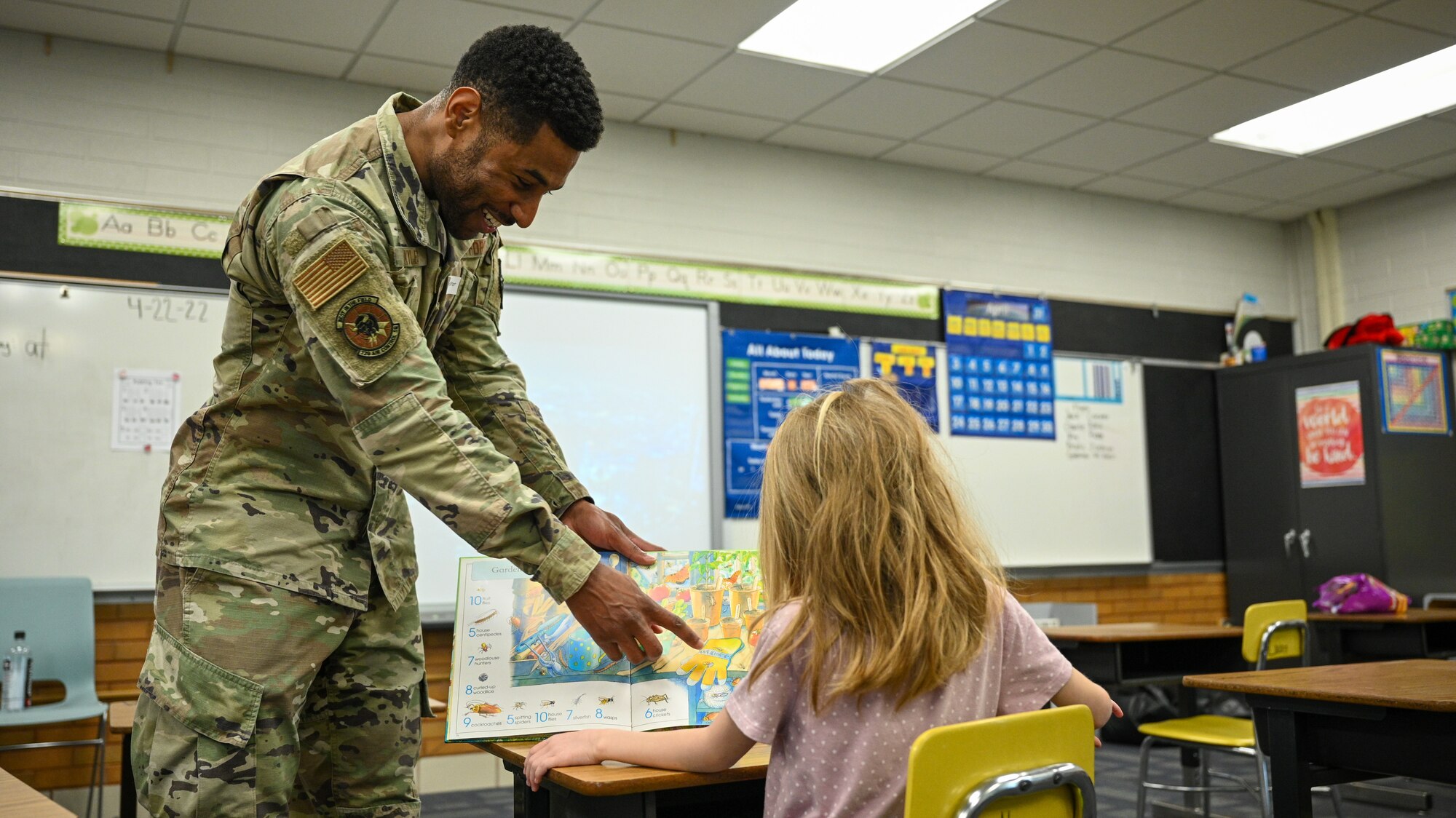 Master Sgt. Laton Kyles, 729th Air Control Squadron, reads with a student at Hill Field Elementary School during a Heroes Reading event, April 22, 2022. The Heroes Reading program is an annual event conducted by the Hill AFB School Liaison office in partnership with local elementary schools. The event is held each spring in conjuction with April's Month of the Military Child. This year marks a relaunch of the program after a hiatus due to the COVID-19 pandemic. During the month, Airmen volunteers will visit three schools and read to more than 1,400 students. (U.S. Air Force photo by R. Nial Bradshaw)