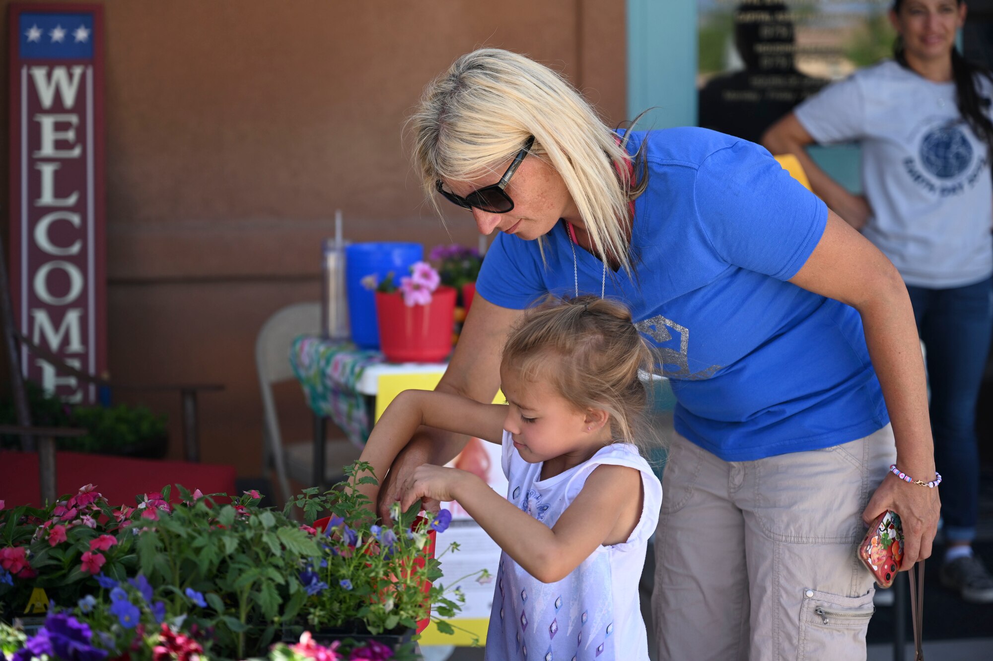Two participants at the Earth Day extravaganza check the soil of a plant at the Soaring Heights Community Center, on Holloman Air Force Base, New Mexico, April 21, 2022. Events such as these are important for the Resident Council, Soaring Heights and other organizations to make connections and keep the base safe and clean. (U.S. Air Force photo by Airman 1st Class Antonio Salfran)