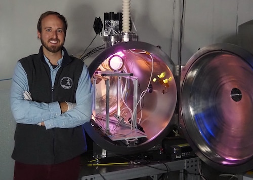 Dr. Miles Bengtson, an Air Force Research Laboratory postdoctoral scientist, stands next to the vacuum chamber in the AFRL Space Vehicles Directorate’s Spacecraft Charging and Instrument Calibration Lab at Kirtland Air Force Base, N.M. in which a multi-energy electron source is developed and tested.