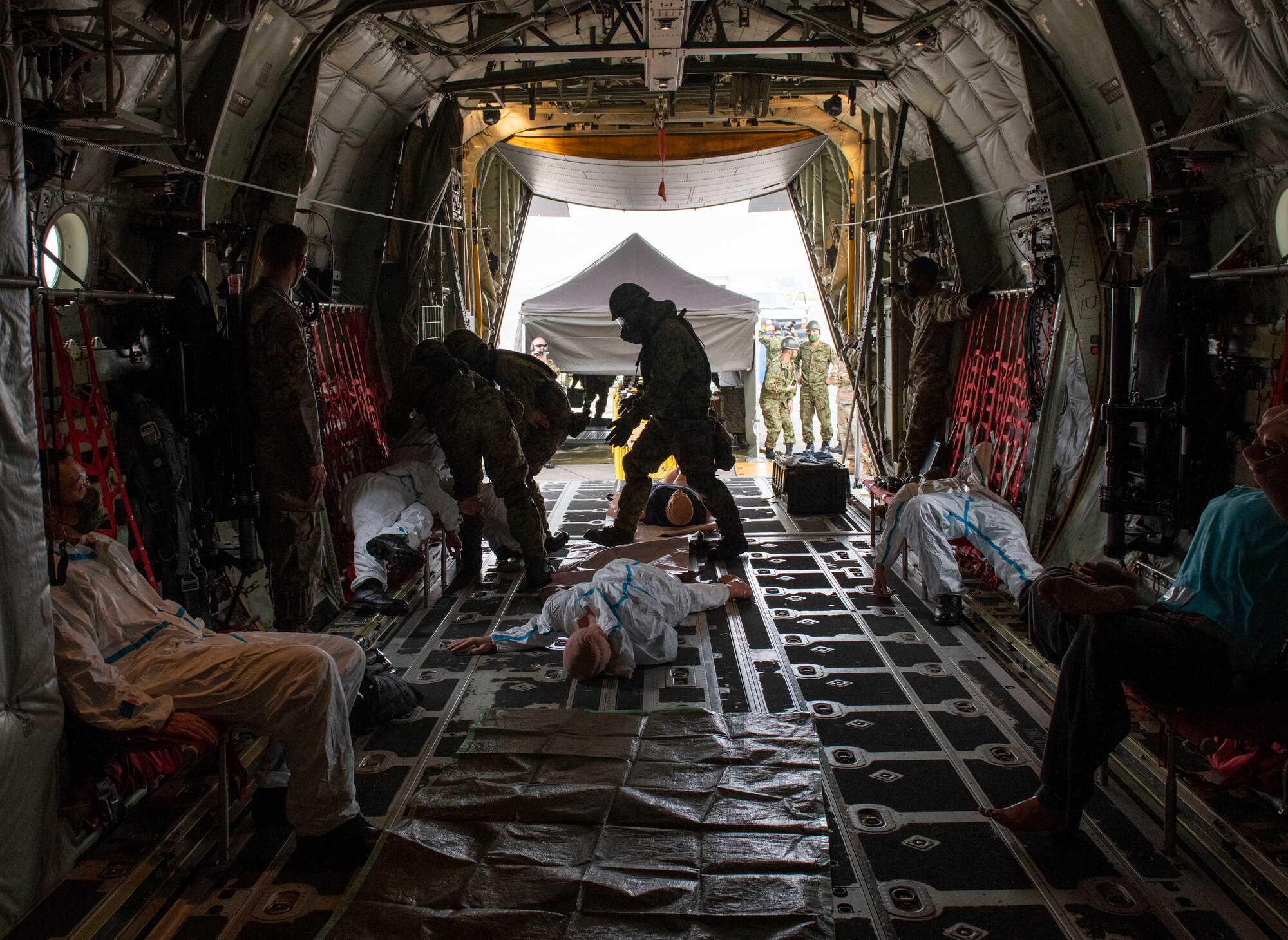 Japan Ground Self-Defense Force Central Biological Chemical Weapons Defense Unit soldiers walk around a C-130J Super Hercules