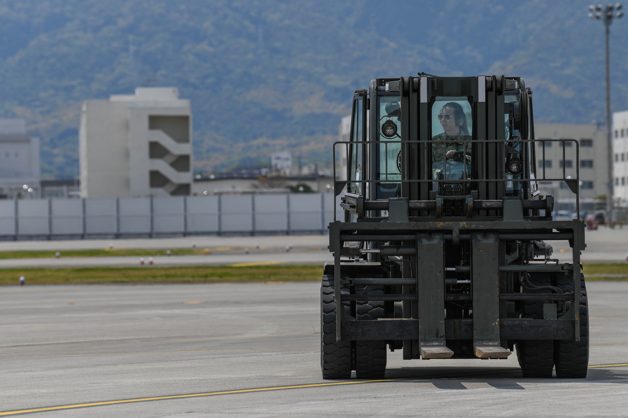 U.S. Air Force 2nd Lt. Megan Irvine, 374th Aircraft Maintenance Squadron officer in charge drives a forklift on a flightline at Marine Corps Air Station Iwakuni, Japan, April 19, 2022. 35 Airmen assigned to Yokota Air Base visited MCAS Iwakuni for joint agile combat employment training with Marines. (U.S. Air Force photo by Staff Sgt. Jessica Avallone)