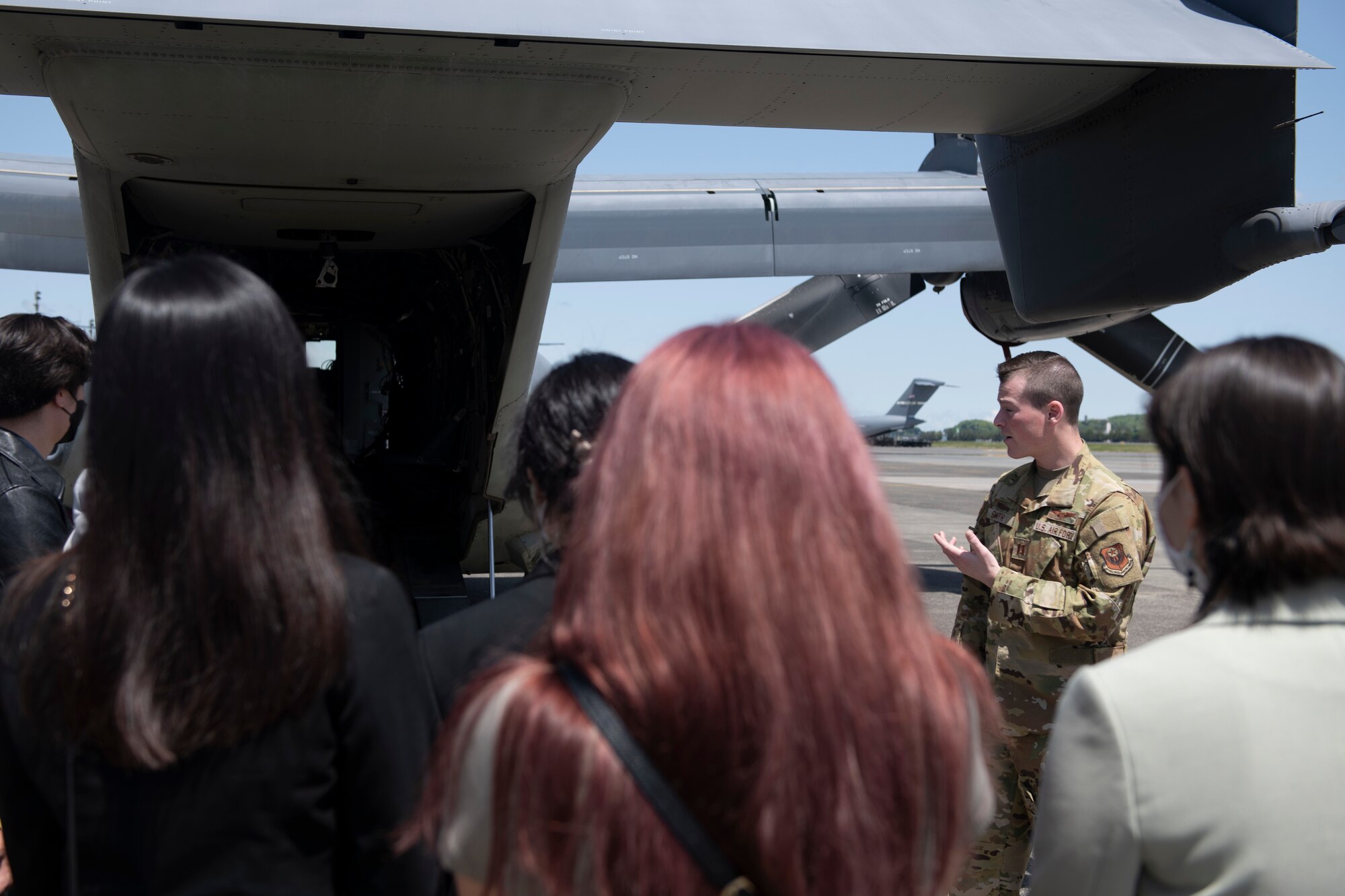 Capt. Andrew Smith, 21st Special Operations Squadron pilot, explains the 21st SOS mission and CV-22 Osprey capabilities during an Ambassador’s Youth Council tour at Yokota Air Base, Japan, April 22, 2022. The AYC received information on how the 374th Airlift Wing operates and supports tenant units include the 21st SOS and Japan Air Self-Defense Force. (U.S. Air Force photo by Tech. Sgt. Joshua Edwards)