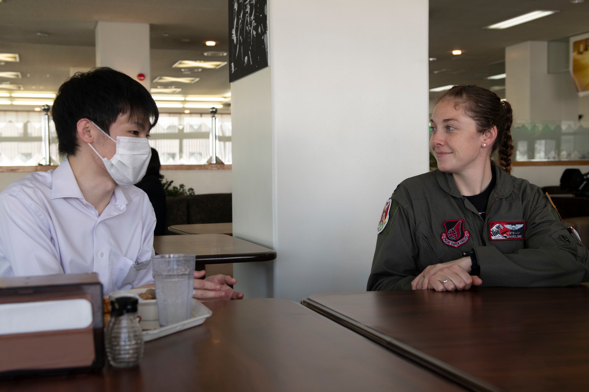 Yo Nonoyama, Ambassador’s Youth Council member, left, talks with Capt. Madeline Atkinson, 36th Airlift Squadron pilot, during a lunch meeting for the AYC at Yokota Air Base, Japan, April 22, 2022. Volunteers across from various squadrons across Yokota took the time to eat lunch with the AYC to give them an insight on what it is like to be a military member and how they support a larger mission. (U.S. Air Force photo by Tech. Sgt. Joshua Edwards)