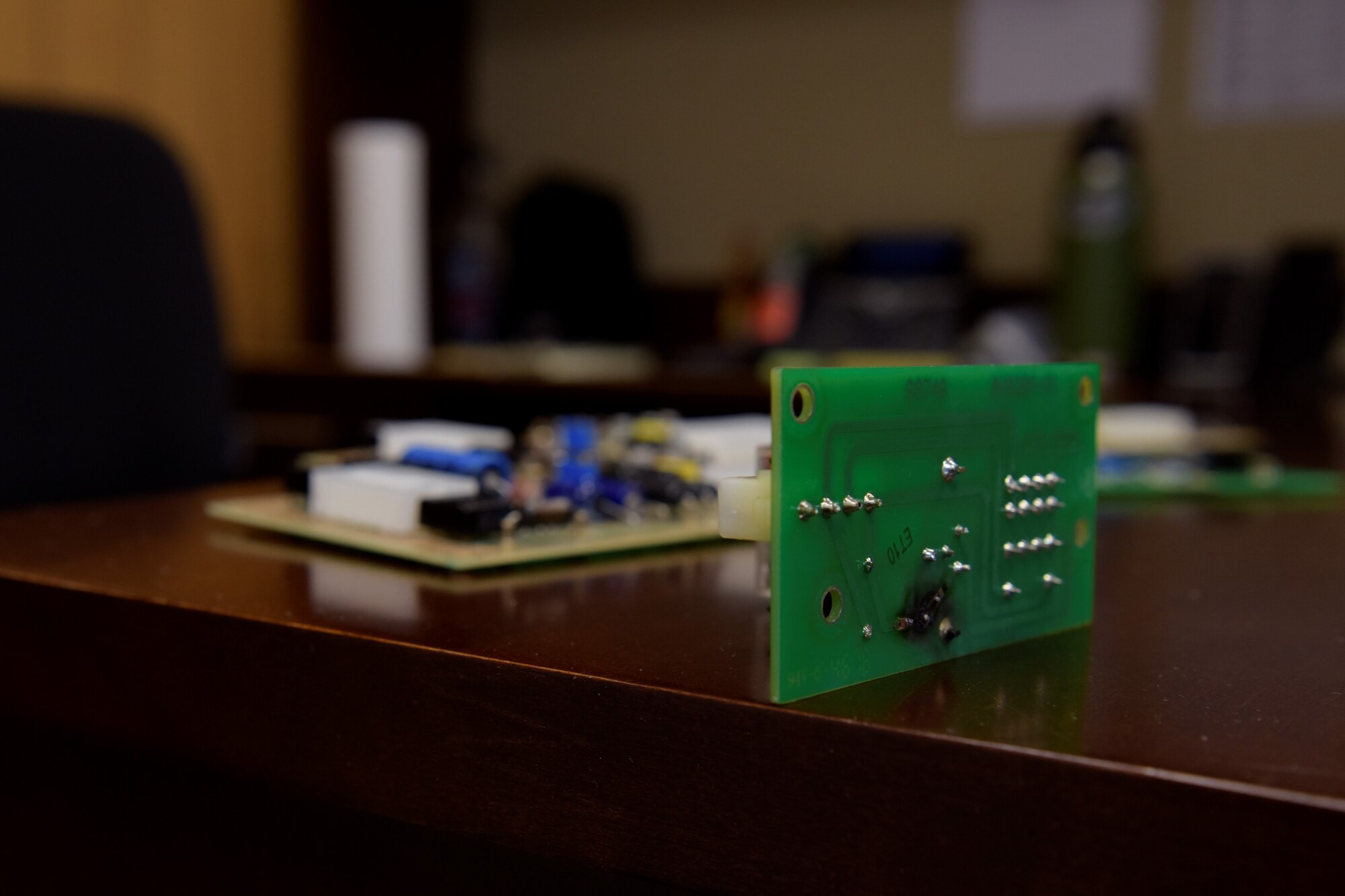 A circuit board with a fried track sits on a desk