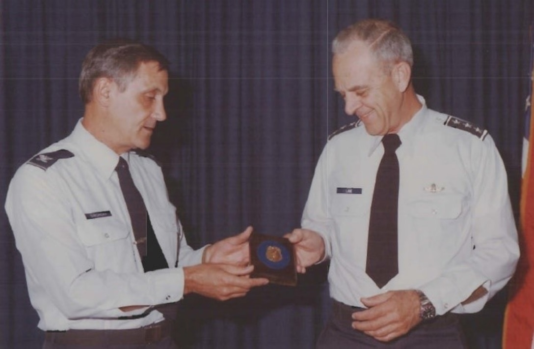 Col. Forest A. Singhoff, OSI Commander, left, presents an OSI badge to Lt. Gen. Howard M. Lane,  Air Force Inspector General, in 1978 (U.S. Air Force photo).