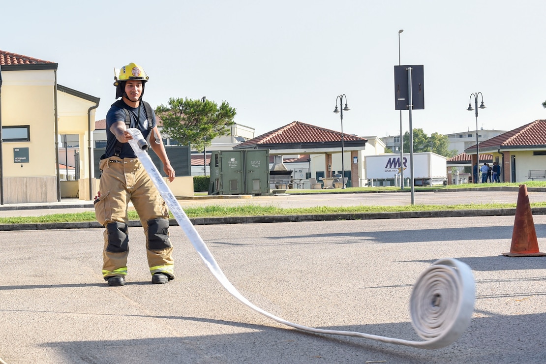 Aviation Boatswain’s Mate (Handling) 1st Class Stephen Andujar, assigned to Naval Support Activity (NSA) Naples Fire Department, rolls out a fire hose in preparation for a live fire training exercise on board NSA Naples’ Support Site, June 26, 2020.