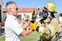 Naval Support Activity (NSA) Naples Fire Chief Nicholas Panzica, left, performs a safety check on the glove of  Marco Annunziata, a local national firefighter at NSA Naples, during a live fire training exercise on board NSA Naples’ Support Site, June 26, 2020.