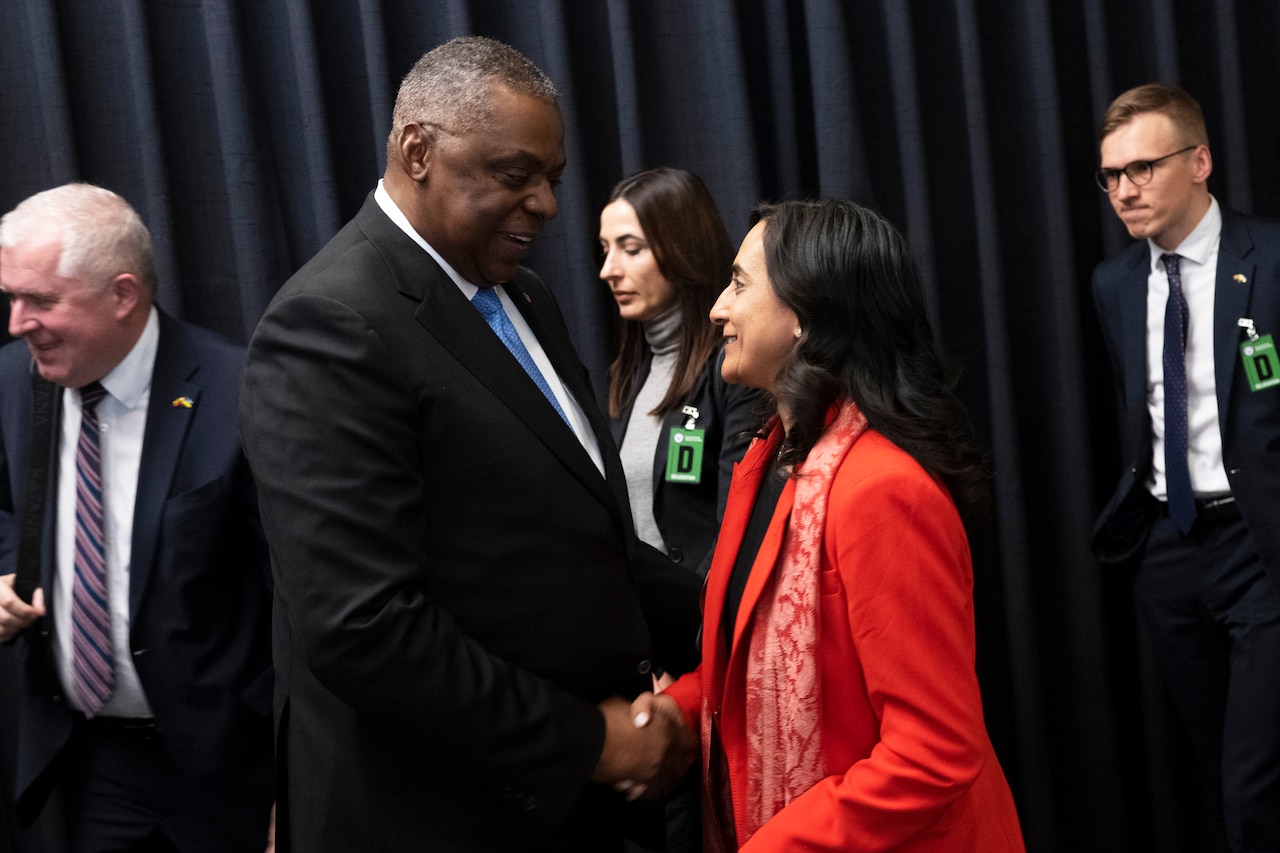 A man and woman shake hands.