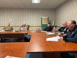 Individuals having conversation around a conference room.